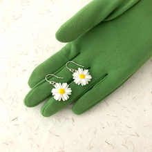 Load image into Gallery viewer, daisy earrings on a green gloved hand
