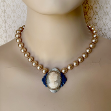 Load image into Gallery viewer, shell cameo necklace on blue and silver coloured frame with champagne coloured pearls displayed on a mannequin