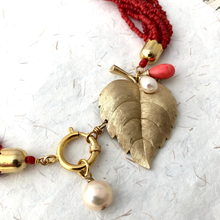 Load image into Gallery viewer, close up of a red necklace with gold leaf and pearl charm against a neutral background