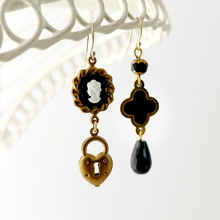 Load image into Gallery viewer, asymmetric black and gold earrings with cameo hanging against a white background