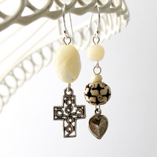 Load image into Gallery viewer, asymmetric earrings with Mother of Pearl, carved bone bead and repurposed charms hanging from a white frame