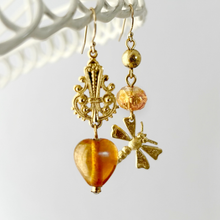 Load image into Gallery viewer, Gold earrings with golden peach beads, gold filigree and dragonfly charm against a light background