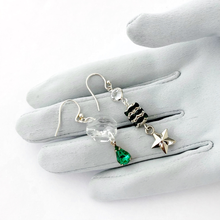 Load image into Gallery viewer, silver and emerald asymmetric earrings with chandelier crystal and star displayed on a grey gloved hand