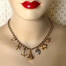 Load image into Gallery viewer, Gold charm necklace on a mannequin with red lips against a patterned background