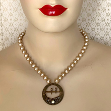 Load image into Gallery viewer, mannequin wearing a necklace with an an antique belt buckle and vintage champagne coloured pearl beads