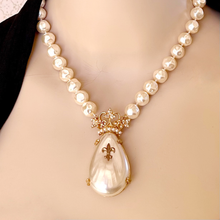 Load image into Gallery viewer, Pearl necklace with a decorative crowned pendant on a mannequin