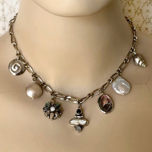 Load image into Gallery viewer, Necklace with various silver, pearl and abalone shell charms on a mannequin