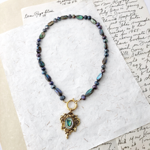 Load image into Gallery viewer, Necklace of paua shell and freshwater pearls with a pendant on a textured paper background
