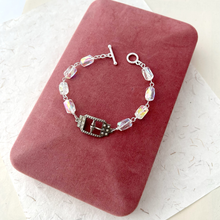 Load image into Gallery viewer, bracelet with small central buckle and crystal beads displayed on a pink jewellery box