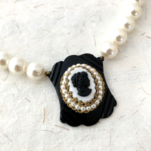 Load image into Gallery viewer, Pearl necklace with a vintage black and white cameo pendant on a textured white background