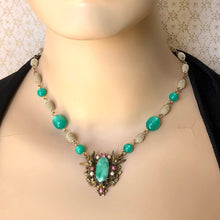 Load image into Gallery viewer, necklace with large focal on green and pale gold beads displayed on a mannequin