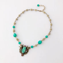 Load image into Gallery viewer, necklace with large focal on green and pale gold beads displayed flat on a white background