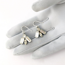 Load image into Gallery viewer, a pair of rhinestone earrings on a gloved hand