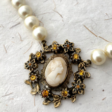 Load image into Gallery viewer, Pearl necklace with a vintage cameo focal on a textured white background