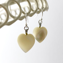 Load image into Gallery viewer, vintage heart-shaped mother of pearl earrings hanging against a white background
