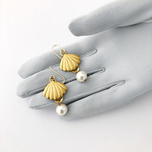 Load image into Gallery viewer, earrings with brass shells and pearl beads on a gloved hand