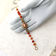 Load image into Gallery viewer, Bracelet with vintage cameo and Carnelian beads displayed on a gloved hand