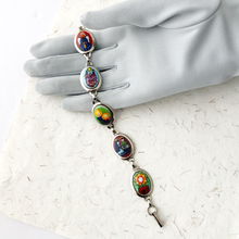 Load image into Gallery viewer, Bracelet with colorful Christmas images displayed on a gloved hand