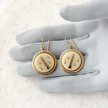 Load image into Gallery viewer, Pair of earrings with musical notes on a hand wearing a gray glove.