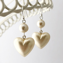 Load image into Gallery viewer, earrings with pearlised beads and hearts hanging from a white frame