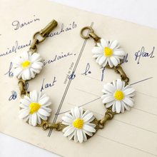 Load image into Gallery viewer, bracelet with vintage plastic daisies displayed on a vintage postcard