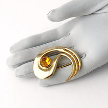 Load image into Gallery viewer, unusual modernist brooch in gold with topaz rhinestone displayed on a gloved hand
