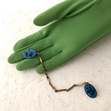 Load image into Gallery viewer, blue enamelled copper sweater clips displayed on a green gloved hand

