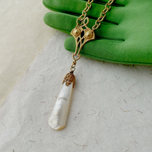 Load image into Gallery viewer, close up of mother of pearl pendant and connecting elements displayed on a green gloved hand
