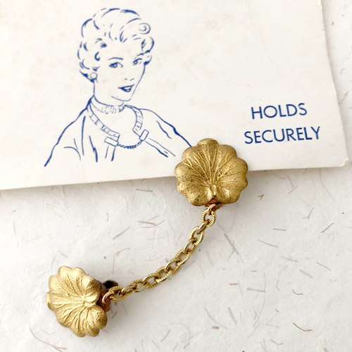 sweater clip with lily pad shaped leaves and vintage image of 1950s woman wearing a sweater clip
