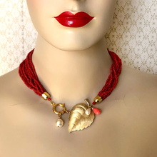 Load image into Gallery viewer, Mannequin wearing a red necklace with gold leaf and pearl charm against a neutral background
