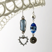 Load image into Gallery viewer, asymmetric earrings in blue and silver hanging from a white frame
