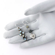 Load image into Gallery viewer, asymmetric earrings in silver and blue colours containing Labradorite and Blue Moonstone displayed on a gloved hand
