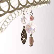 Load image into Gallery viewer, asymmetric earrings in pink and silver hanging from a white frame
