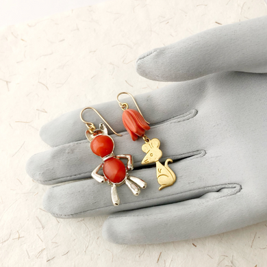 cat and mouse earrings on a gloved hand