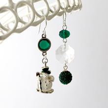 Load image into Gallery viewer, Asymmetric earrings in emerald and crystal with vintage snowman charm hanging against a white background
