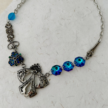 Load image into Gallery viewer, closer look at vintage assemblage necklace in blue and silver tones displayed on handmade paper

