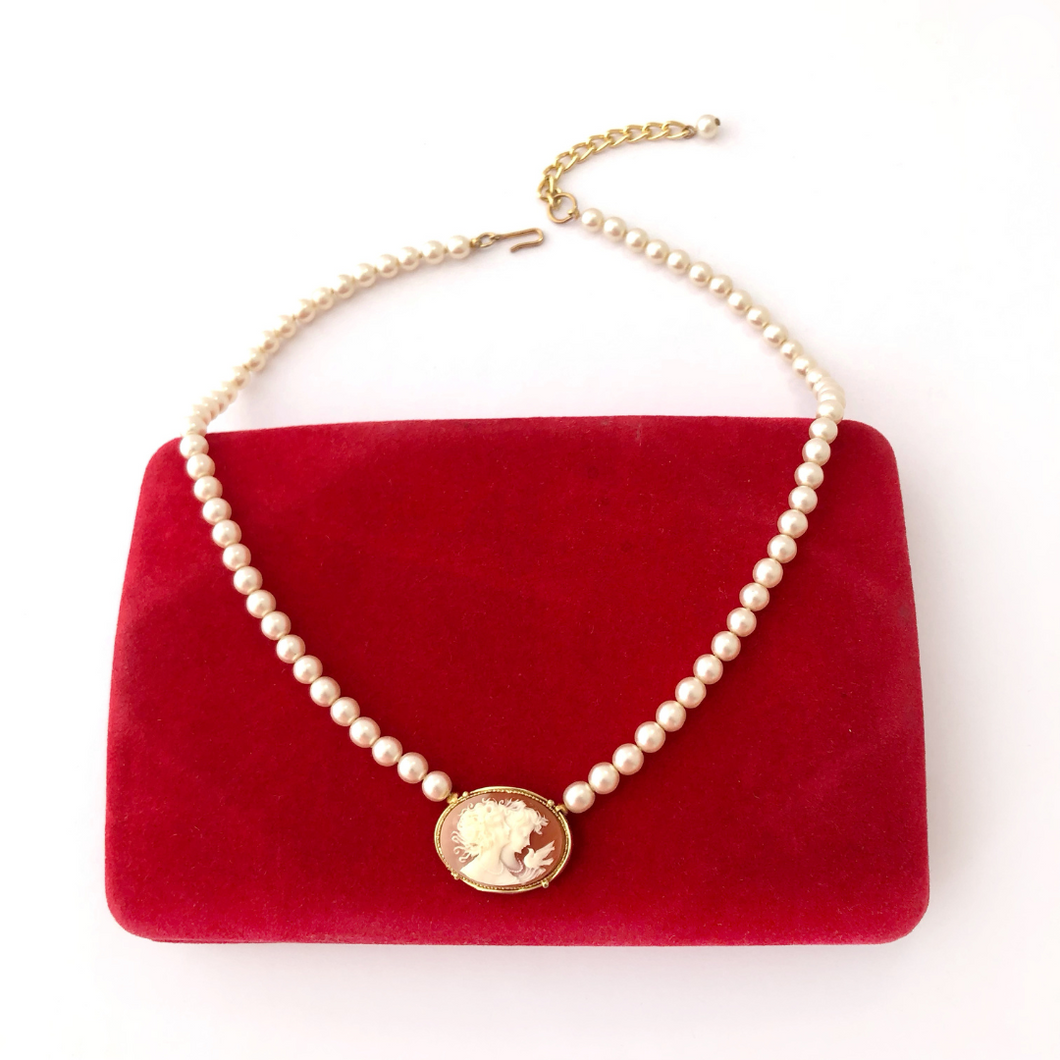 pearl and cameo necklace displayed on a vintage red velvet jewellery box