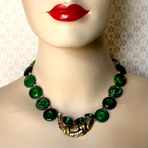 statement necklace in antique gold with emerald green buttons displayed on a mannequin