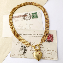 Load image into Gallery viewer, necklace of brick chain with front opening clasp and large brass heart locket set with a Swarovski flat back rhinestone 
