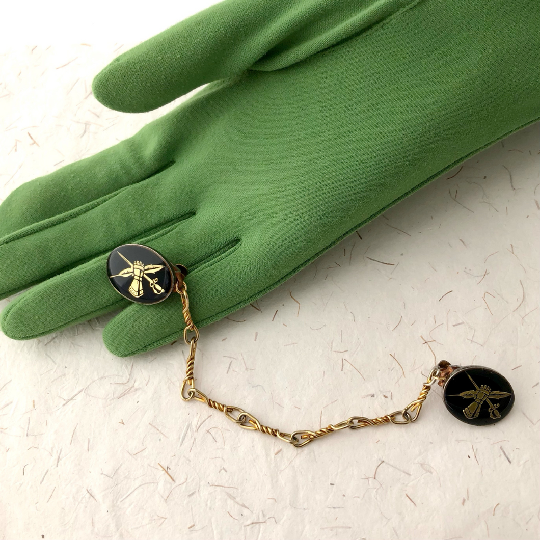 a heraldic themed sweater clip displayed on a green gloved hand
