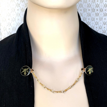 Load image into Gallery viewer, mannequin in jacket held closed with a heraldic themed sweater clip 
