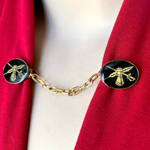 Load image into Gallery viewer, close-up of sweater clip or cloak clasp with heraldic theme on a red jacket
