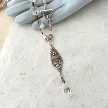 Load image into Gallery viewer, A close-up of a the focal in a reimagined vintage necklace draped over a grey gloved hand.
