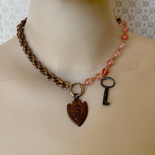 Load image into Gallery viewer, necklace with old medallion and key, cherry quartz beads and vintage chain on a mannequin
