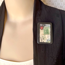 Load image into Gallery viewer, Mannequin wearing black jacket with handmade brooch featuring vintage papers, music and Australian stamp

