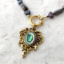 Load image into Gallery viewer, Necklace with a gold pendant featuring an abalone shell on a textured white background
