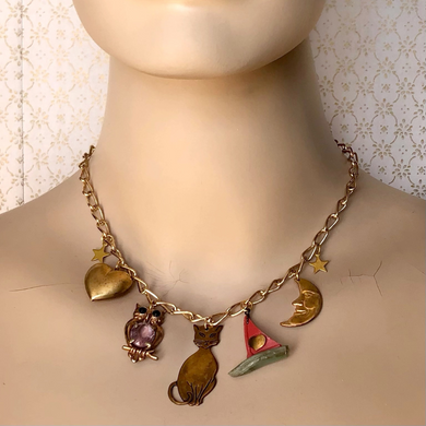 charm necklace telling the story of the owl and the pussycat on a mannequin