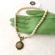 Load image into Gallery viewer, necklace featuring a vintage perfume locket and mid-century pearl beads displayed on a gloved hand
