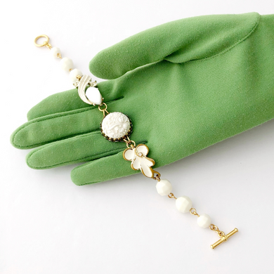 reimagined vintage bracelet in white displayed on a green gloved hand