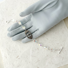 Load image into Gallery viewer, bracelet with small central buckle and crystal beads displayed on a grey gloved hand
